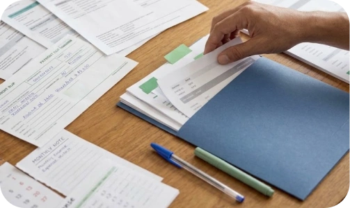 Passo 01: documentos e planilhas espalhados sobre uma mesa de madeira